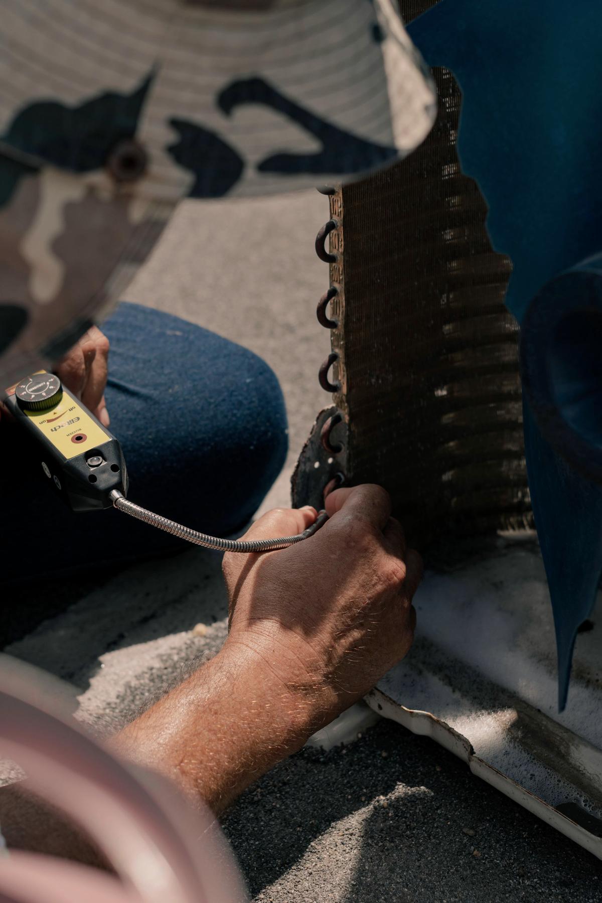 Technician working on the coil of an air conditioning unit
